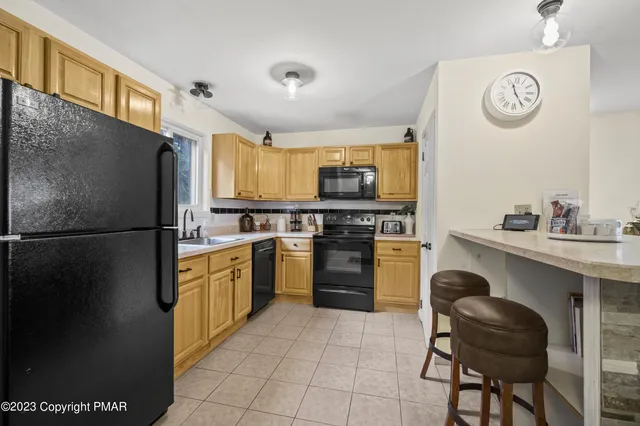 a kitchen with a refrigerator and a stove top oven