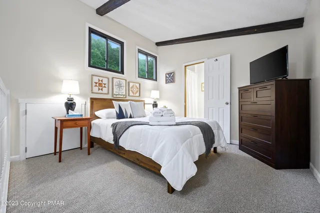 a bedroom with a bed and a flat screen television