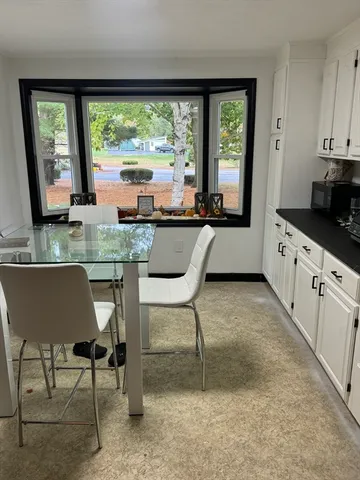 a kitchen with kitchen island a large window in it and dining table