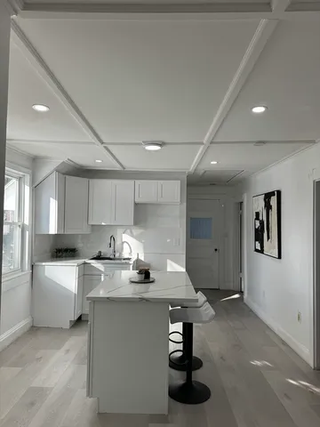 a room with kitchen island a sink table and chairs