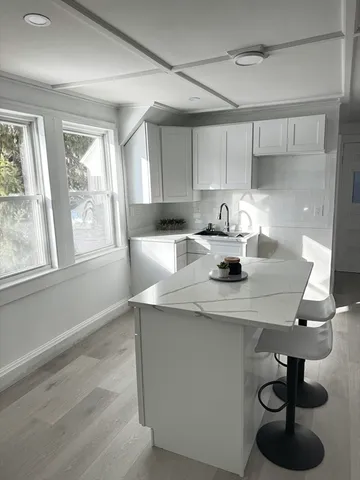 a kitchen with a table chairs and cabinets