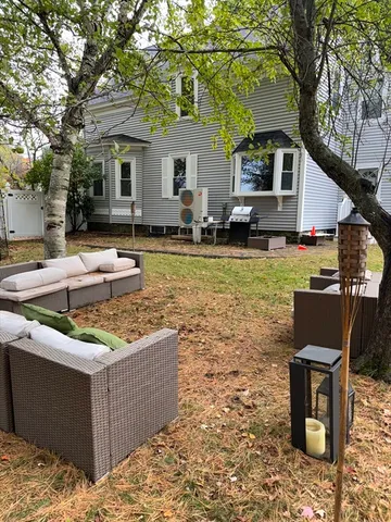a view of a house with backyard and sitting area