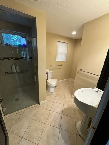 a bathroom with a toilet a sink and mirror