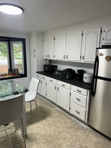 a kitchen with granite countertop white cabinets and white appliances