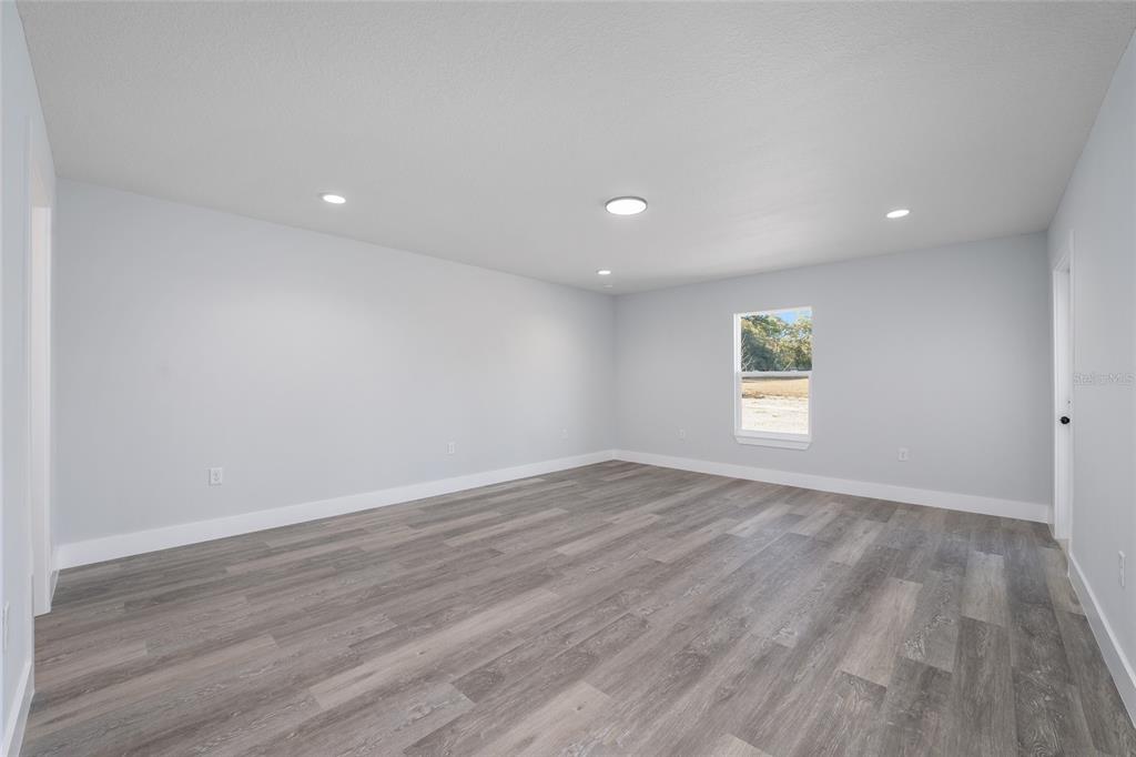 13750 Southwest 113th Lane Dunnellon, FL 34432 - Photo 13 of 26 a view of an empty room with wooden floor and a window