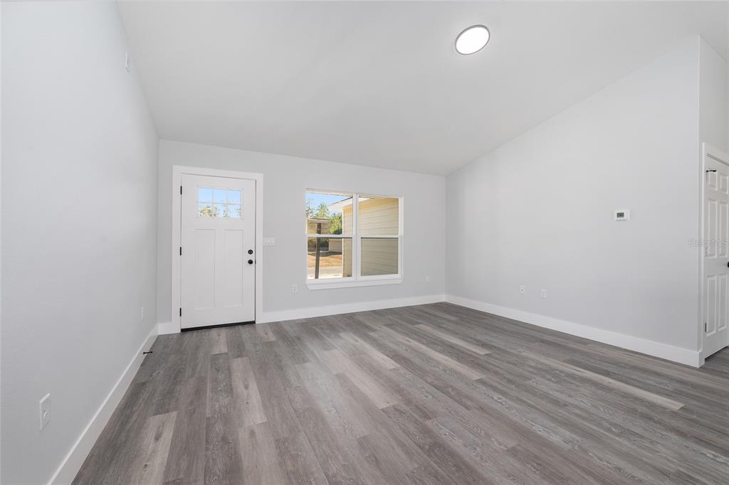 13750 Southwest 113th Lane Dunnellon, FL 34432 - Photo 2 of 26 an empty room with wooden floor and windows