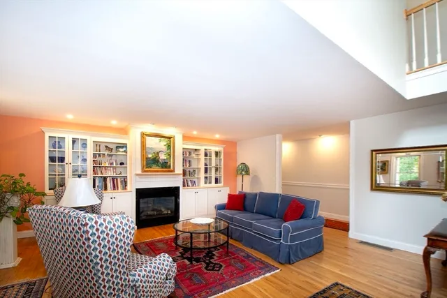 a living room with furniture fireplace and wooden floor
