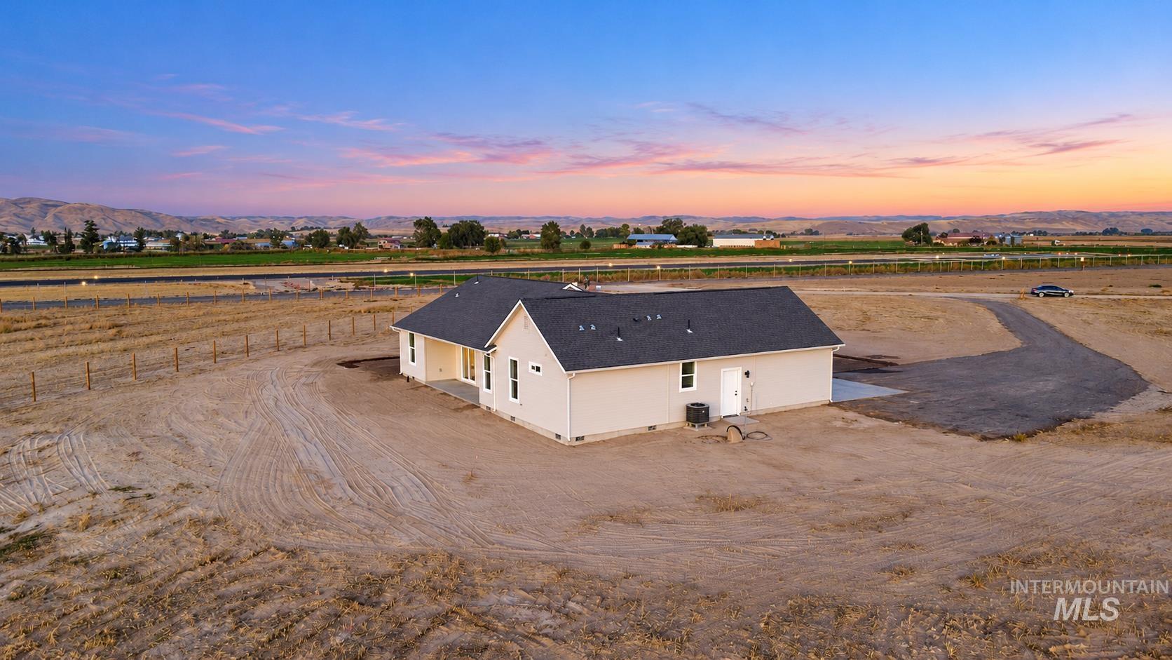 1371 Hansen Road Weiser, ID 83672 - Photo 42 of 44 Newly constructed single-story residence with light-toned siding, a dark roof, and an asphalt driveway