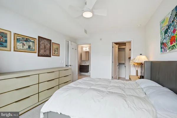 a bedroom with a bed and painting on the wall