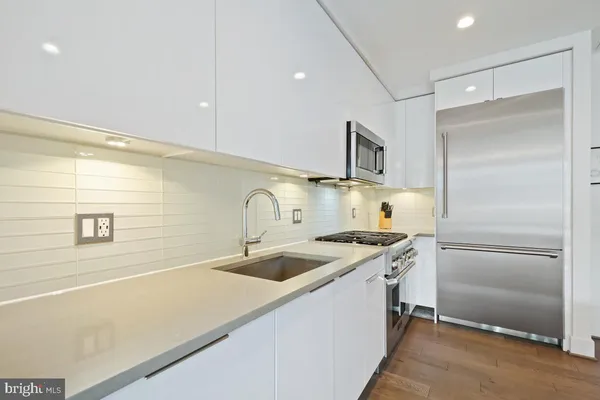 a kitchen with stainless steel appliances granite countertop a sink and a refrigerator