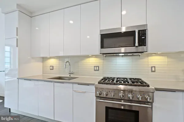 a kitchen with stainless steel appliances granite countertop a stove and a microwave