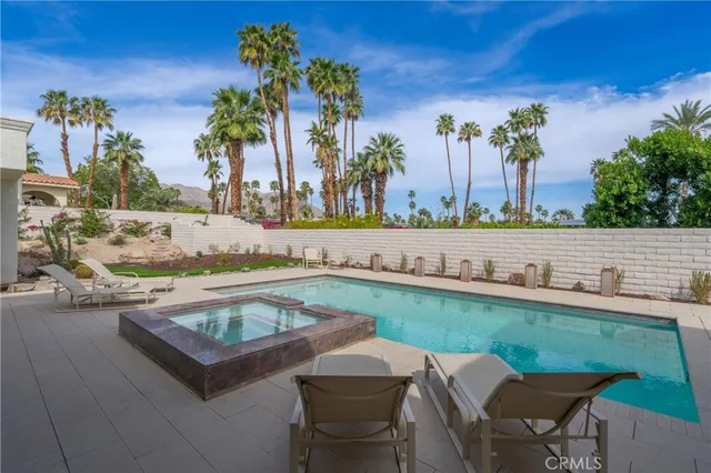a view of a house with swimming pool and sitting area