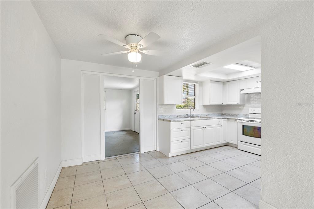 10803 Hyssop Street Port Richey, FL 34668 - Photo 9 of 42 a kitchen with white cabinets and appliances
