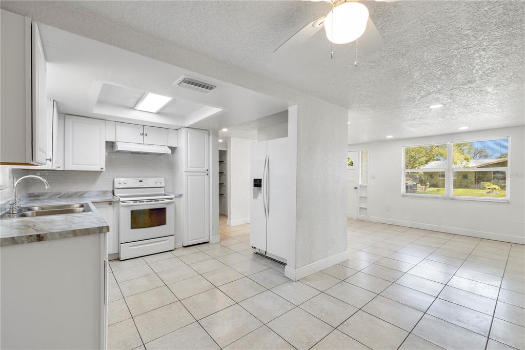 10803 Hyssop Street Port Richey, FL 34668 - Photo 10 of 42 a kitchen with a stove a sink and a refrigerator