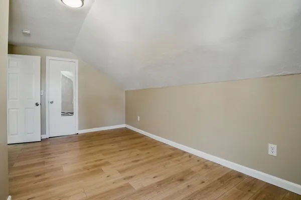 a view of an empty room with wooden floor