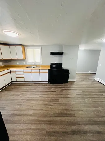 a large kitchen with stainless steel appliances wooden cabinets and a granite counter top