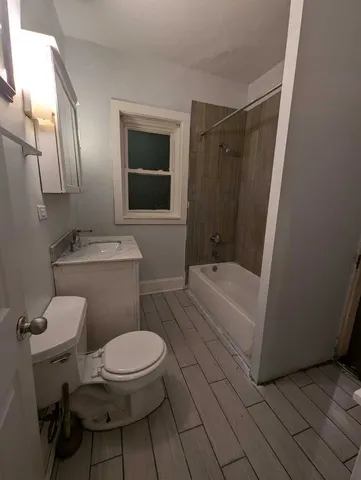 a white toilet sitting next to a bathroom sink and a tub