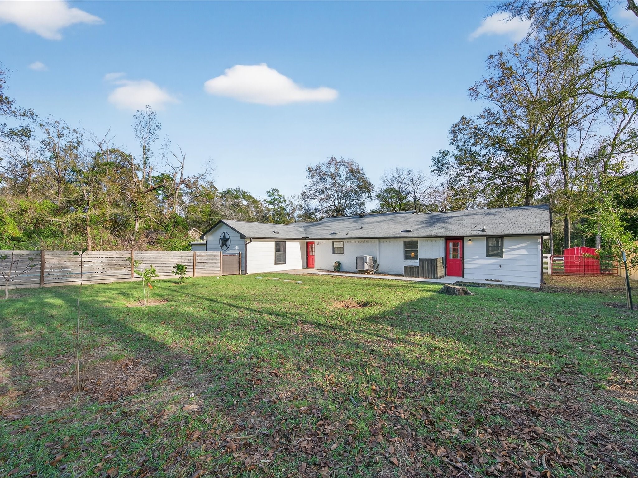 10277 Champion Forest Loop Conroe, TX 77303 - Photo 35 of 45 a view of a big house with a big yard and large trees