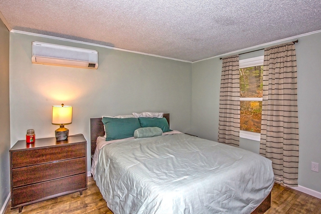 4498 High Street Palmer, MA 01069 - Photo 18 of 26 a large bed sitting in a bedroom next to a window and a lamp