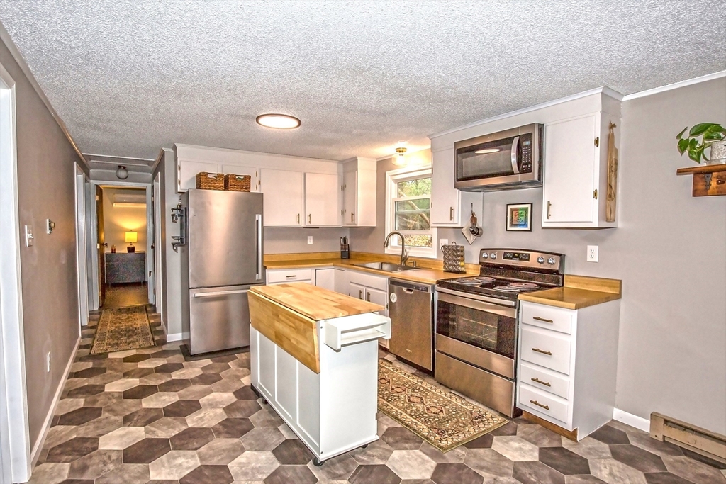 4498 High Street Palmer, MA 01069 - Photo 5 of 26 a kitchen with a stove a refrigerator and a sink