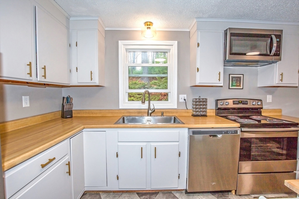 4498 High Street Palmer, MA 01069 - Photo 8 of 26 a kitchen with a sink stove and cabinets