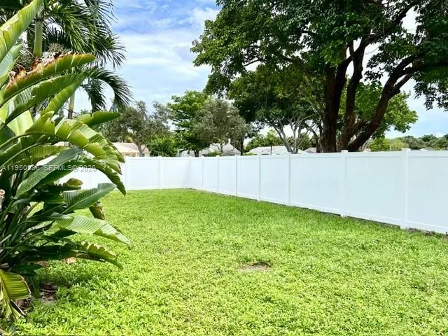 a palm tree sitting in front of a house with a yard