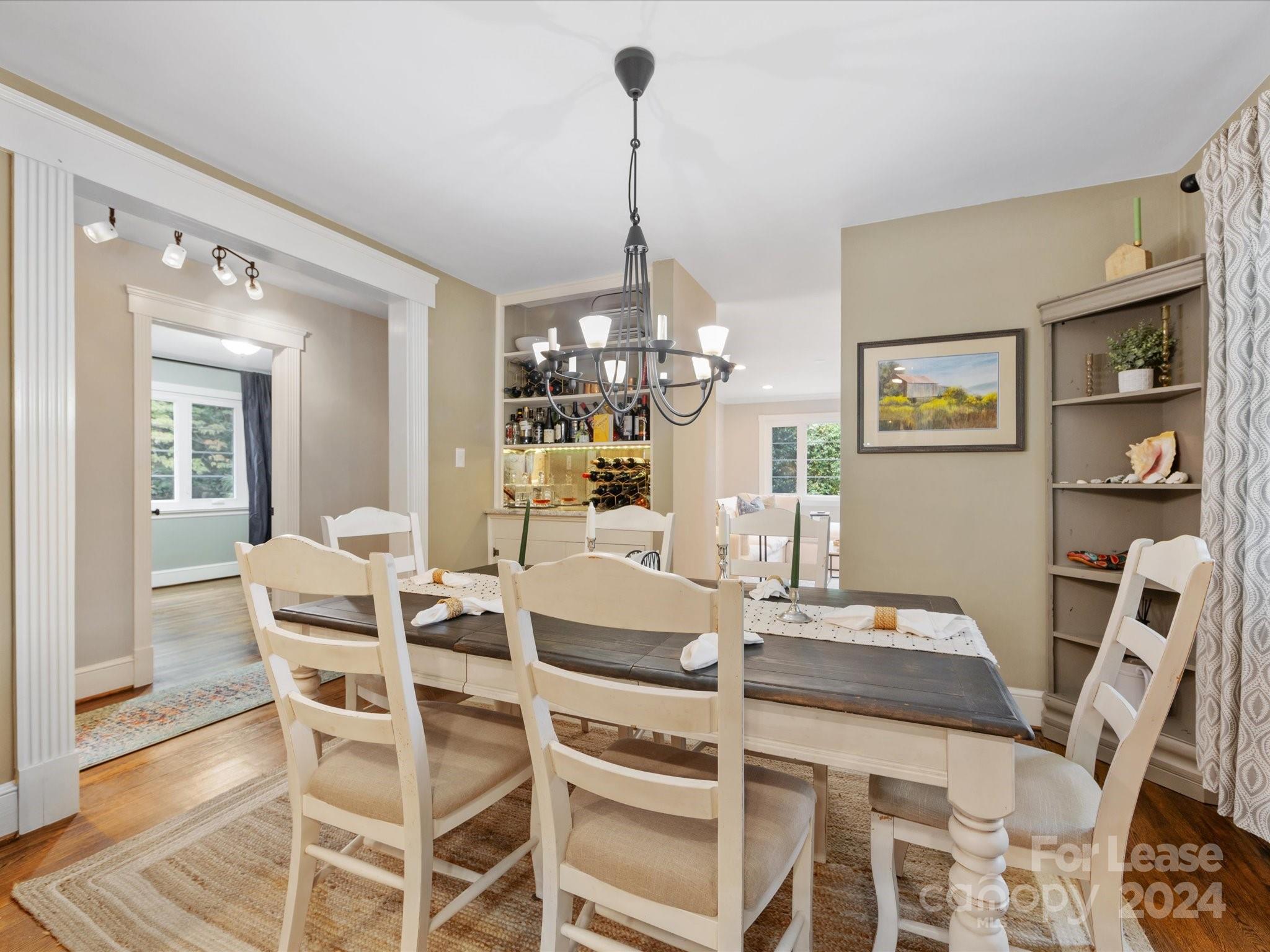 4411 Castleton Road Charlotte, NC 28211 - Photo 12 of 45 a dining room with furniture a chandelier and wooden floor