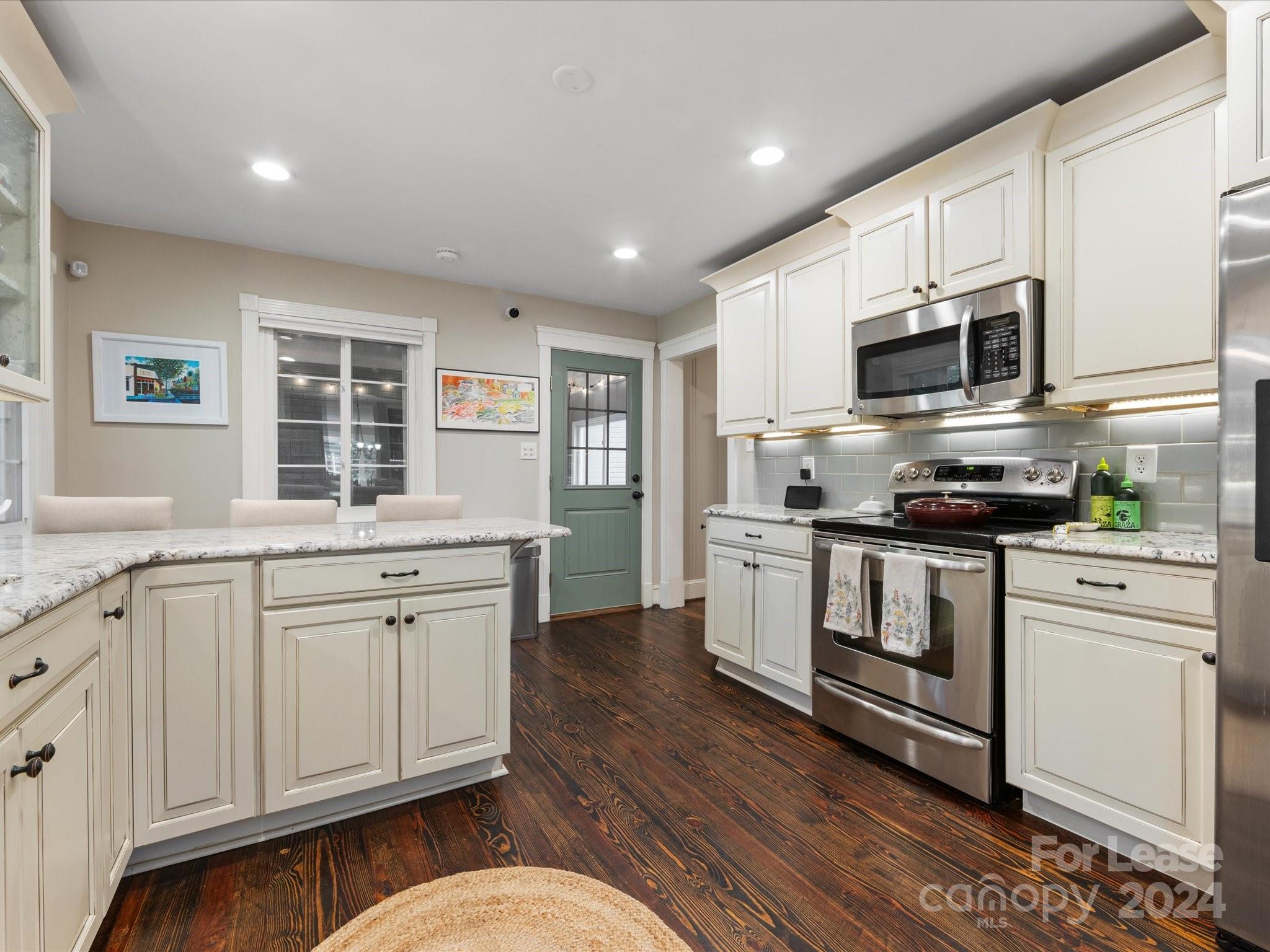 4411 Castleton Road Charlotte, NC 28211 - Photo 19 of 45 a kitchen with stainless steel appliances granite countertop a stove a sink and a microwave