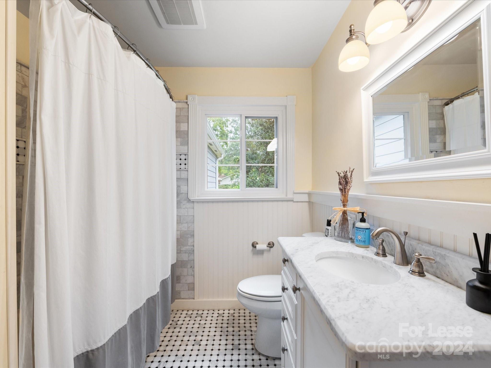 4411 Castleton Road Charlotte, NC 28211 - Photo 32 of 45 a bathroom with a granite countertop sink toilet and mirror