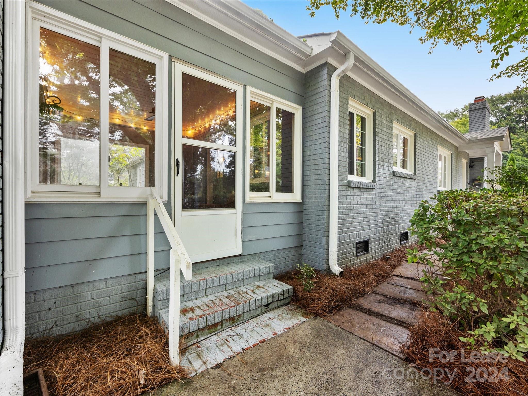 4411 Castleton Road Charlotte, NC 28211 - Photo 5 of 45 a front view of a house with a large window and potted plants