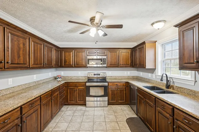 a kitchen with granite countertop a refrigerator and a sink