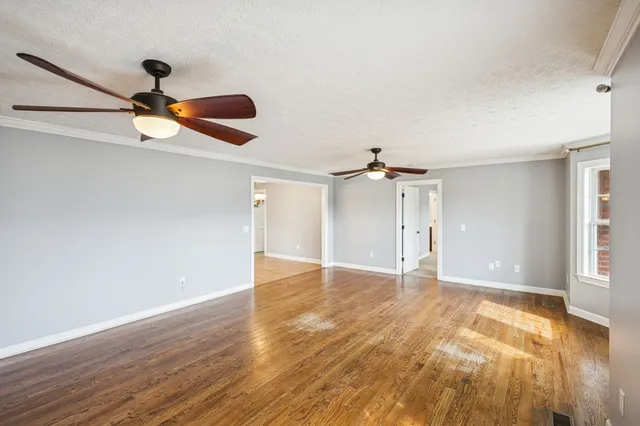 a view of an empty room with wooden floor