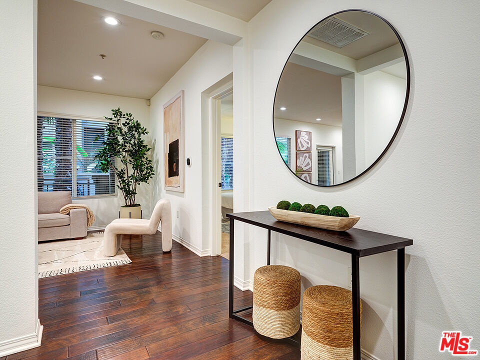 6020 South Seabluff Drive, Unit 122 Playa Vista, CA 90094 - Photo 3 of 33 a living room with furniture a mirror and a wooden floor