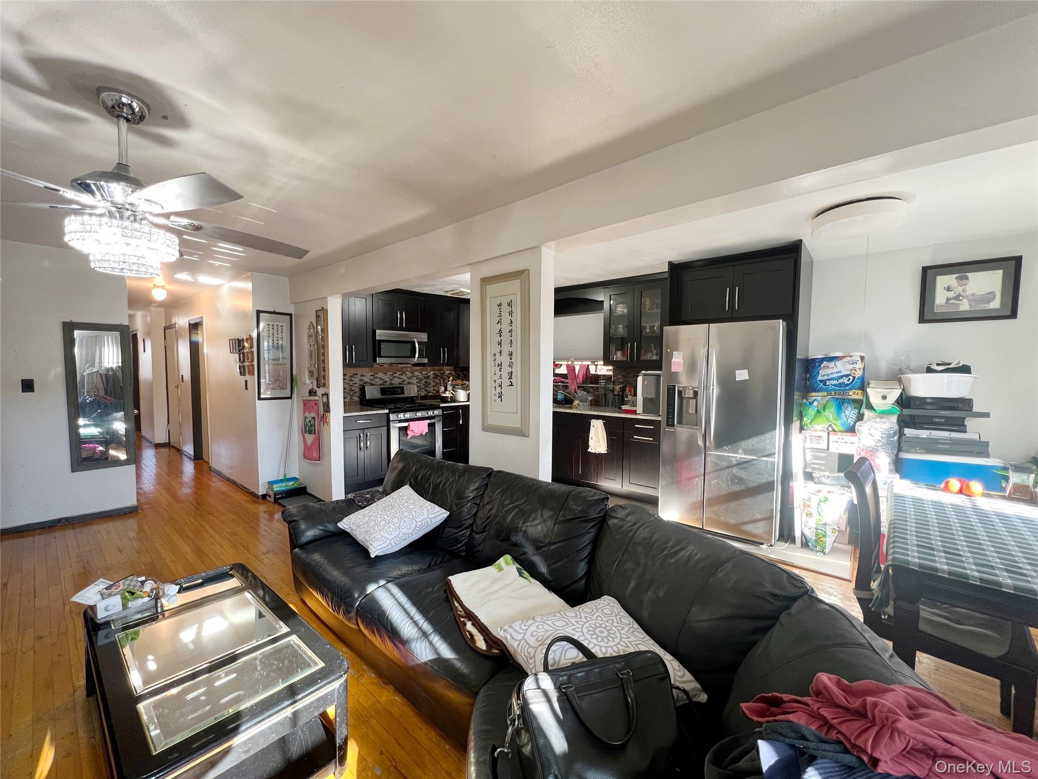 219-74 64th Avenue, Unit 239 Queens, NY 11364 - Photo 11 of 12 a living room with furniture and a chandelier