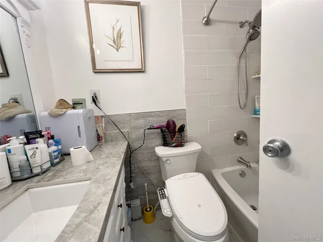 a white toilet sitting next to a bathroom sink and tub