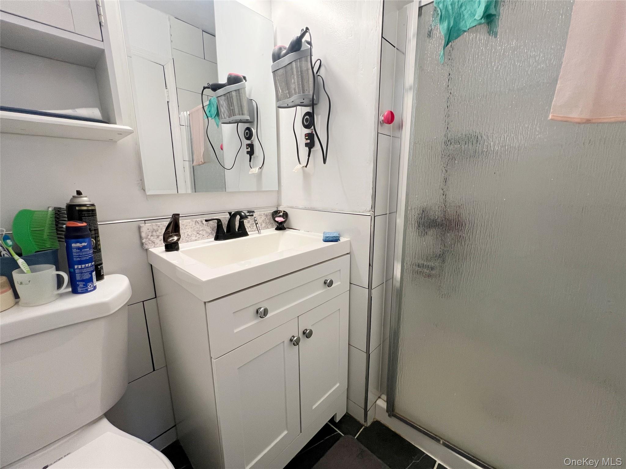 219-74 64th Avenue, Unit 239 Queens, NY 11364 - Photo 8 of 12 a bathroom with a sink toilet and shower