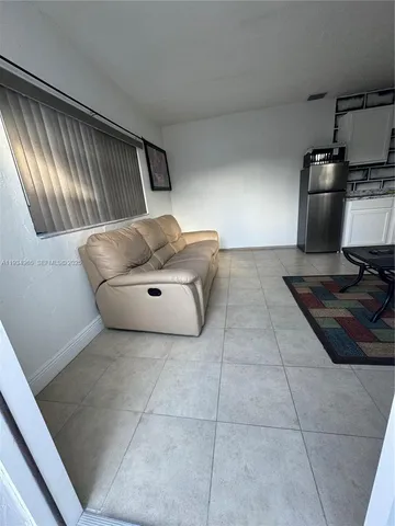 a living room with couches and kitchen view