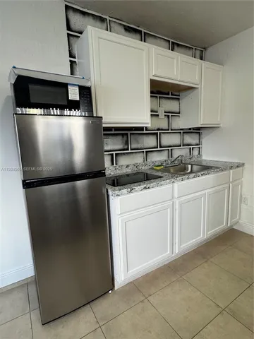a kitchen with stainless steel appliances granite countertop a refrigerator a sink and a stove