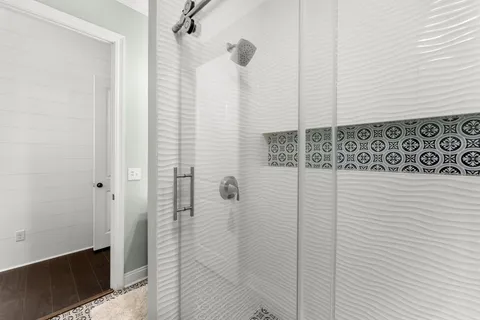 a spacious bathroom with a granite countertop double vanity sink a mirror and a bathtub