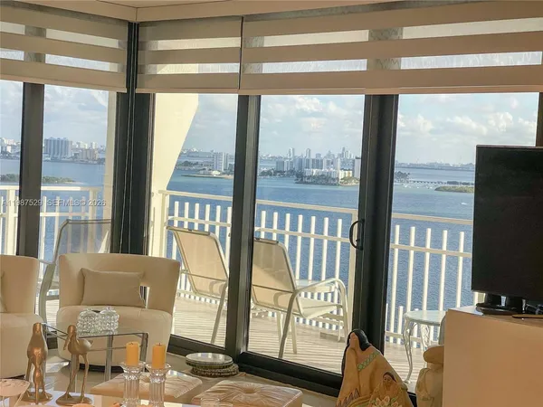 a view of a room with furniture and large windows