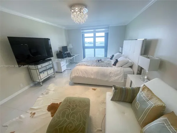 a spacious bedroom with a bed and a flat screen tv