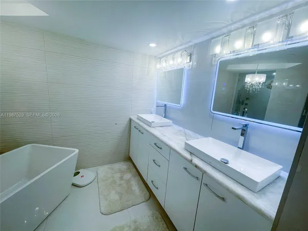 a bathroom with a tub sink and mirror