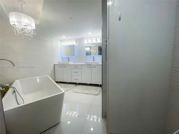 a bathroom with a tub sink and mirror