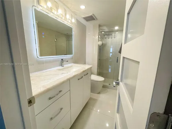 a bathroom with a double vanity sink toilet and shower