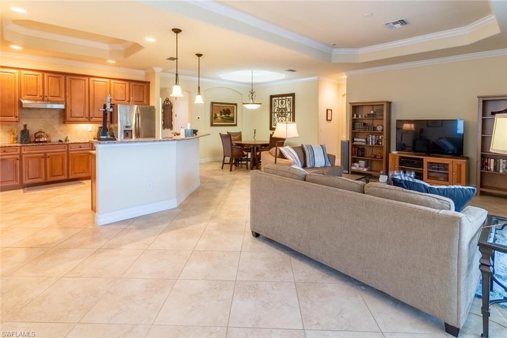 9458 Piacere Way Naples, FL 34113 - Photo 3 of 50 a living room with couches and kitchen view with wooden floor