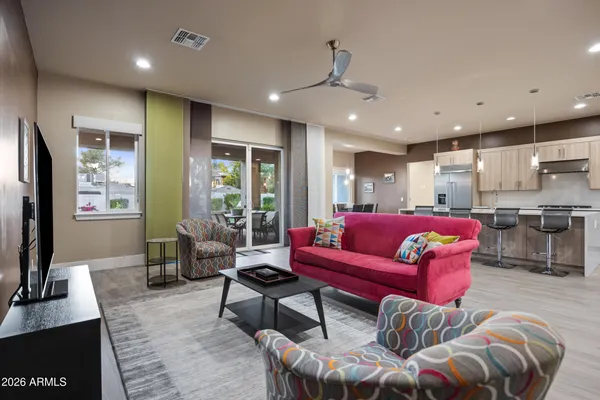 a living room with furniture kitchen view and a flat screen tv