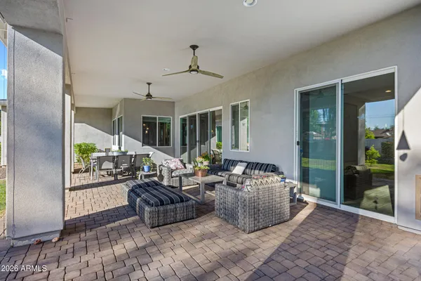a living room with patio furniture and a potted plant