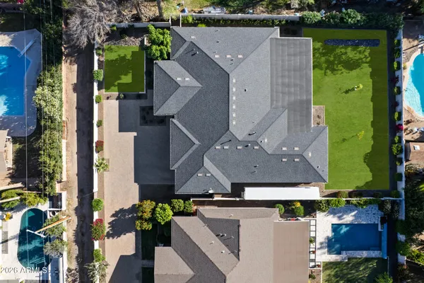 an aerial view of a house with a yard and large trees