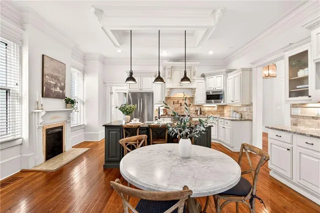 a view of a dining room and livingroom with furniture wooden floor a chandelier