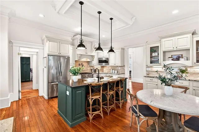 a kitchen with a stove a sink a center island and wooden floor